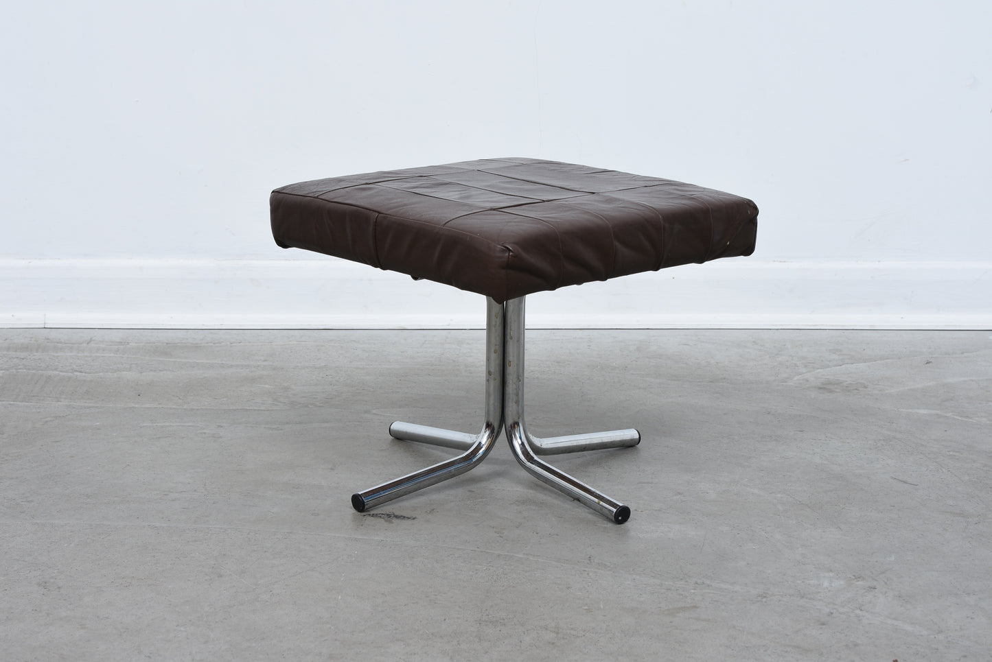 Vintage leather foot stool on metal base