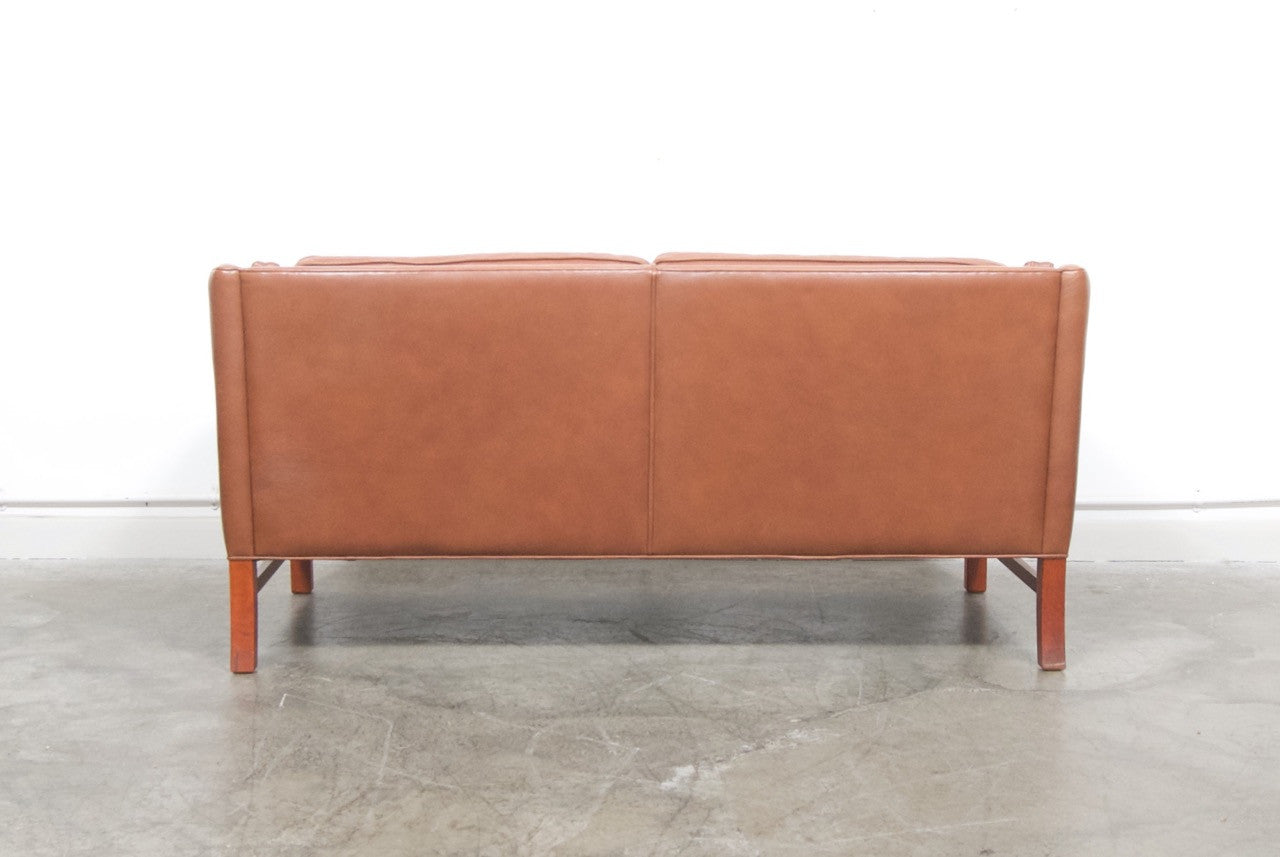 Scalloped back leather two seat sofa
