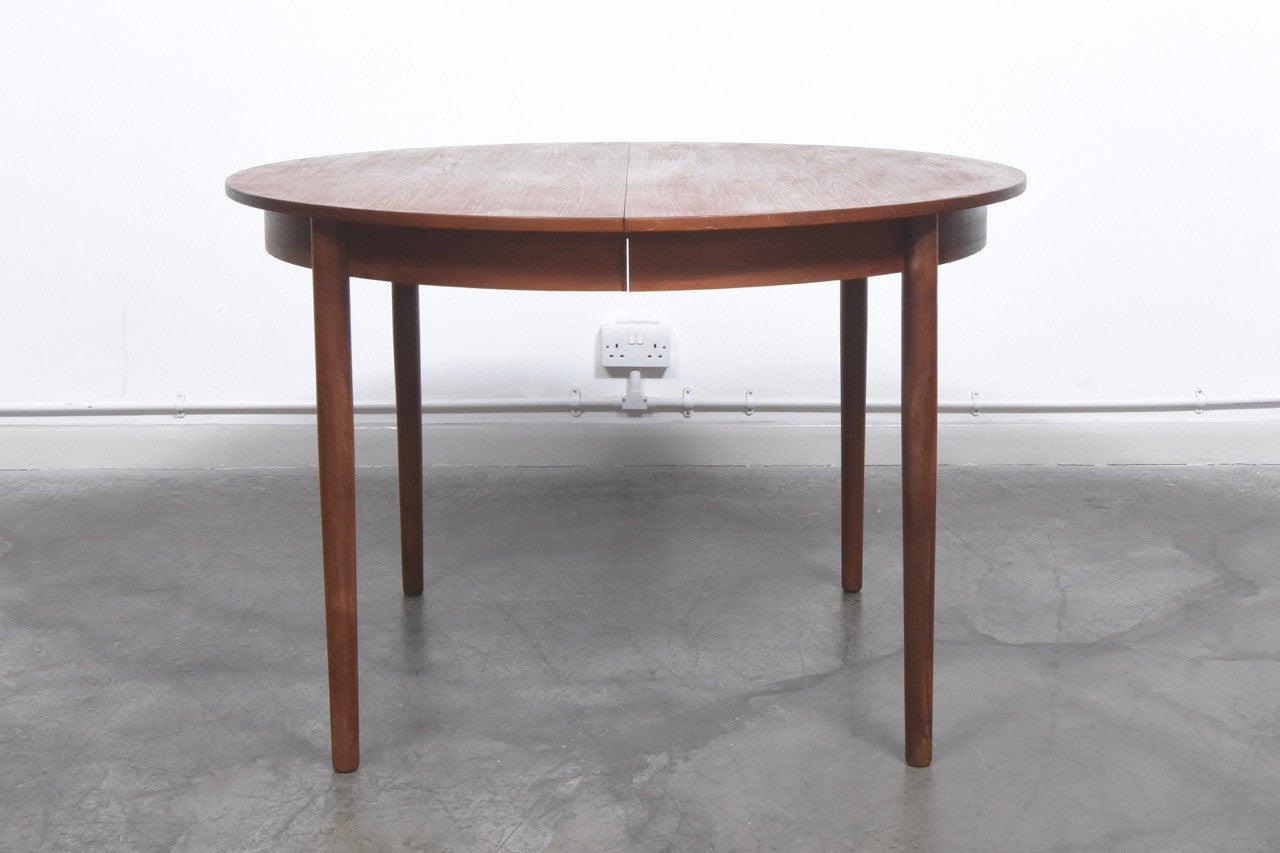Extending round teak dining table
