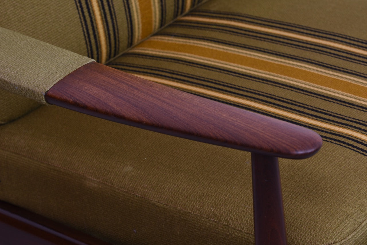 Low back lounger in teak with upholstered arms