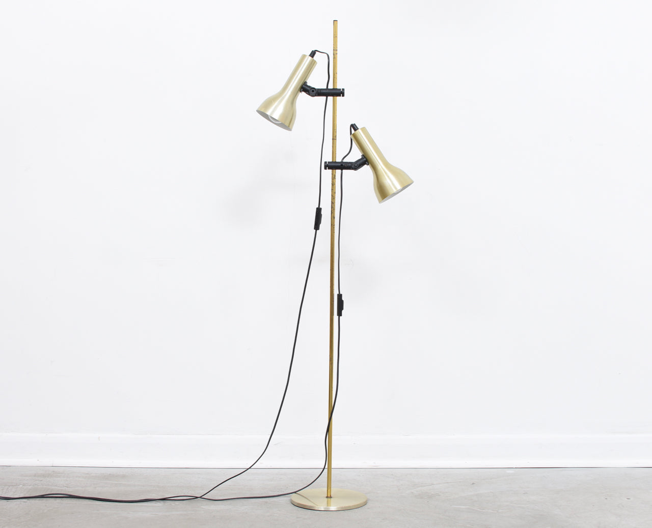 Twin-headed floor lamp with brass finish