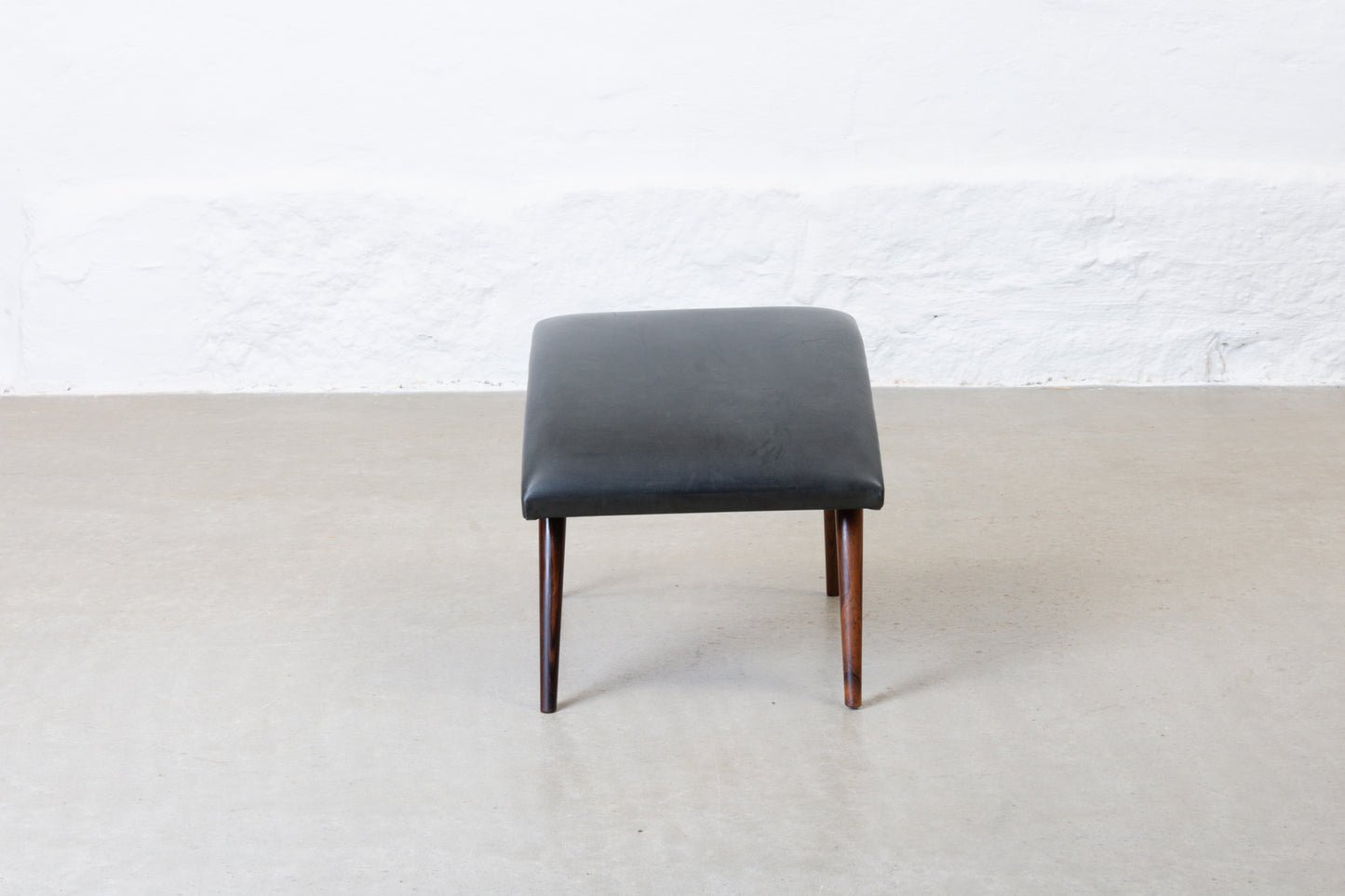 1960s leather foot stool on rosewood legs