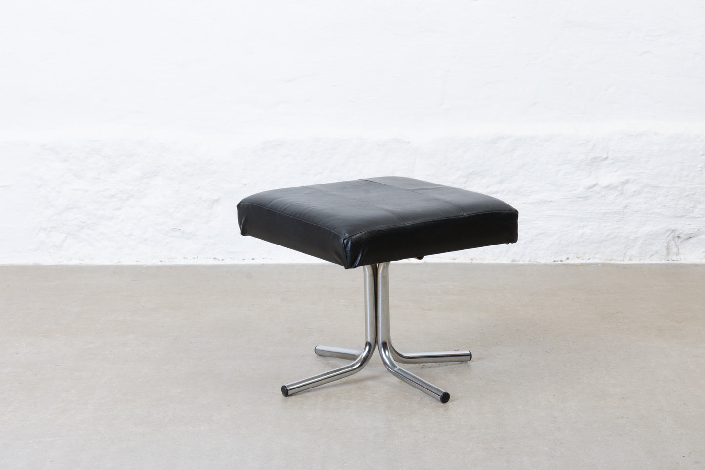 Vintage leather foot stool on metal base