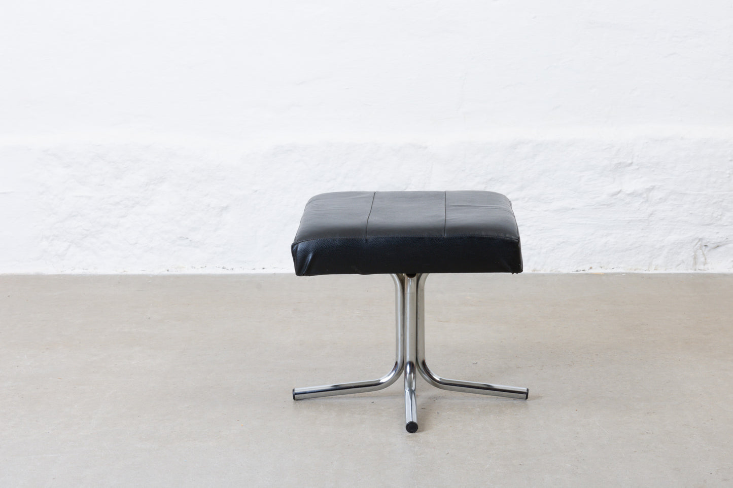 Vintage leather foot stool on metal base