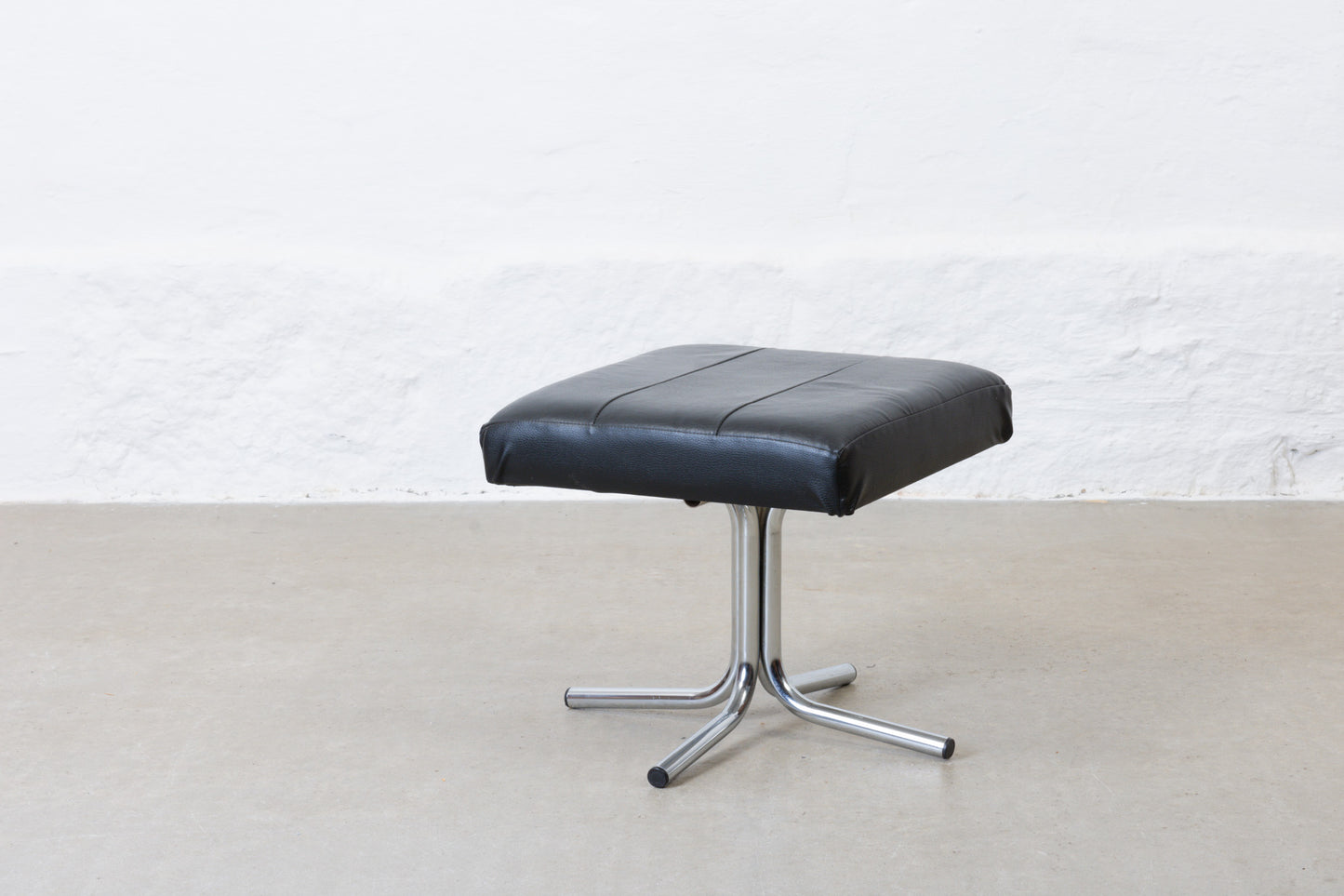 Vintage leather foot stool on metal base