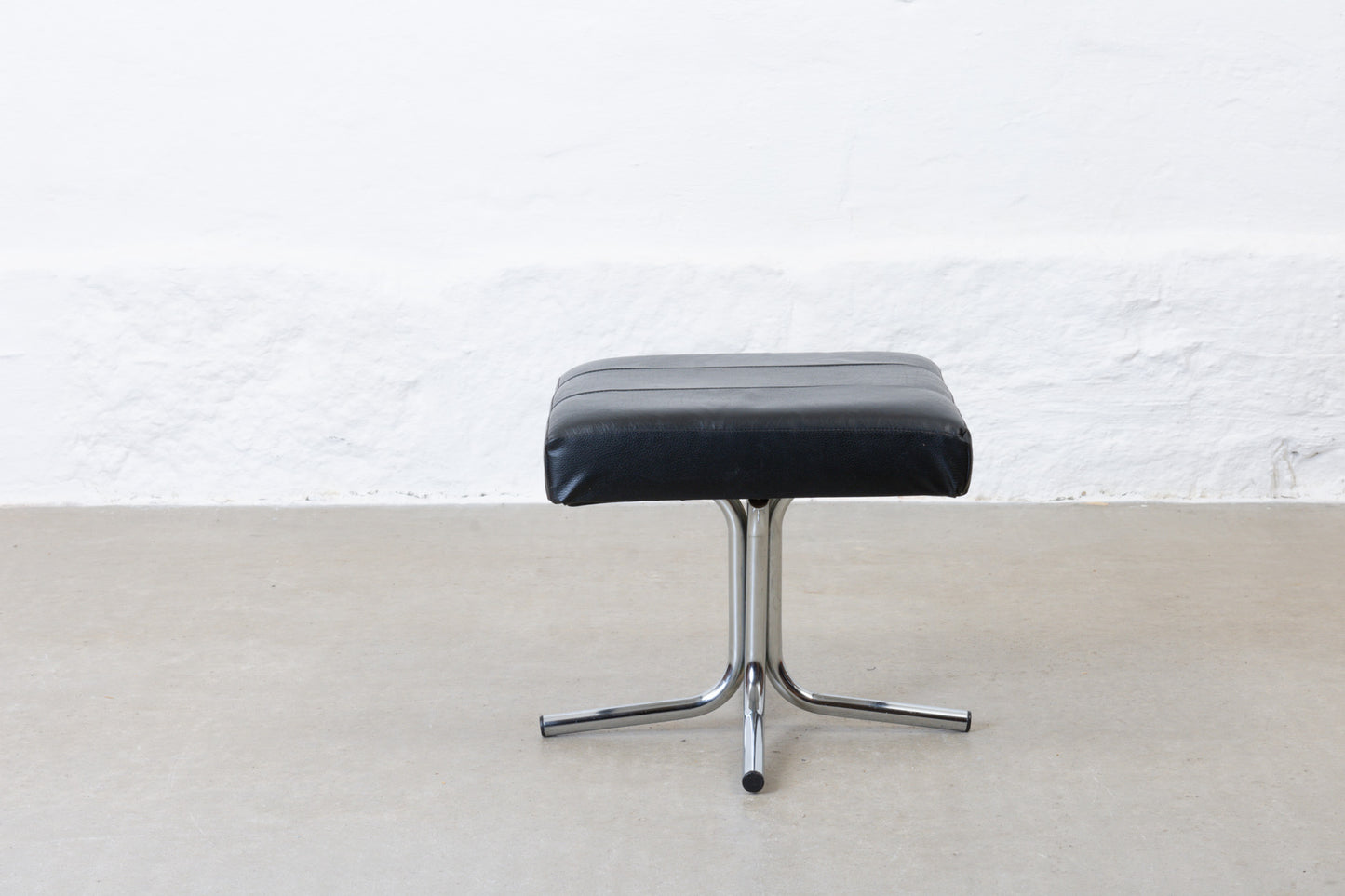 Vintage leather foot stool on metal base
