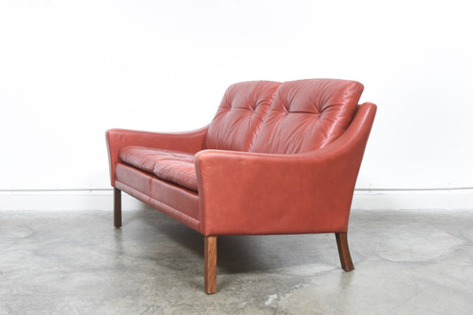 Red leather two seat sofa