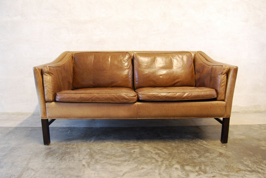 Two seat leather sofa with scalloped back