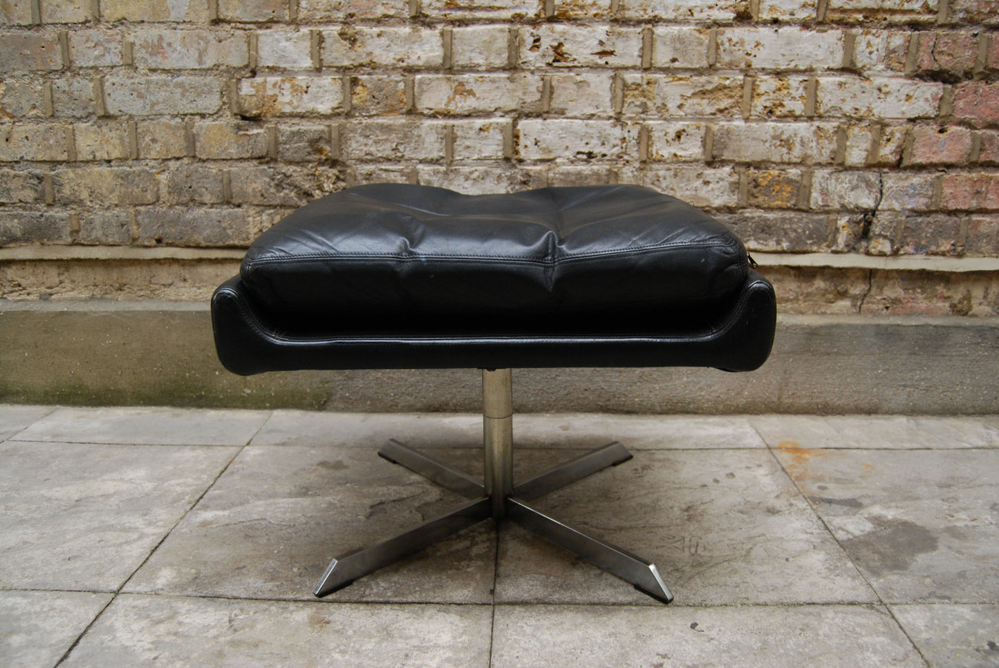 Black leather foot stool with chrome base