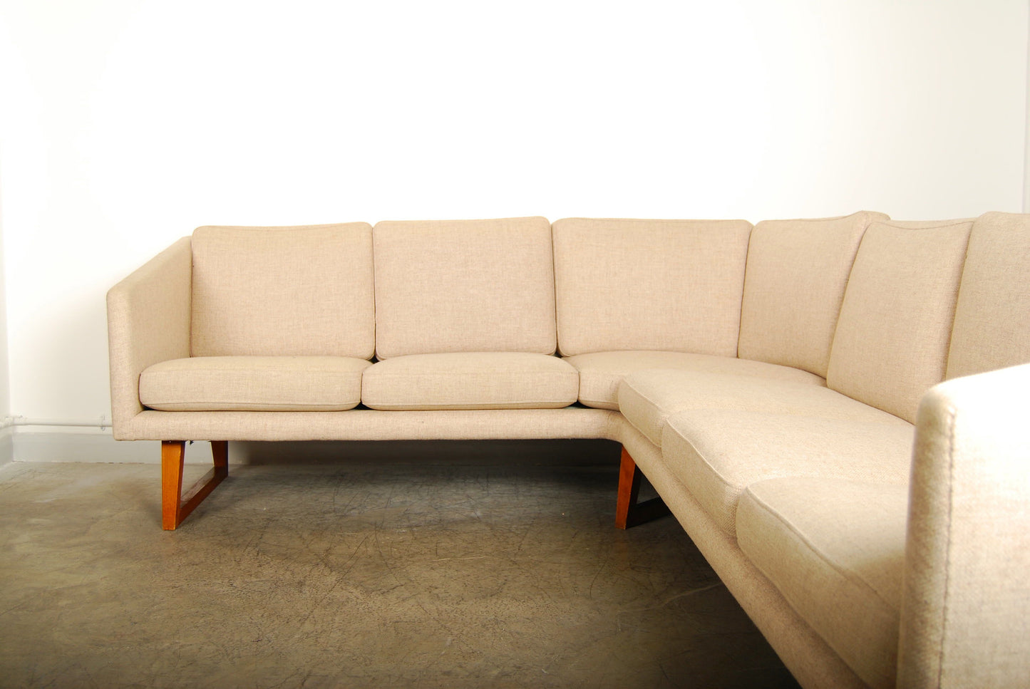 Corner sofa in wool on teak legs