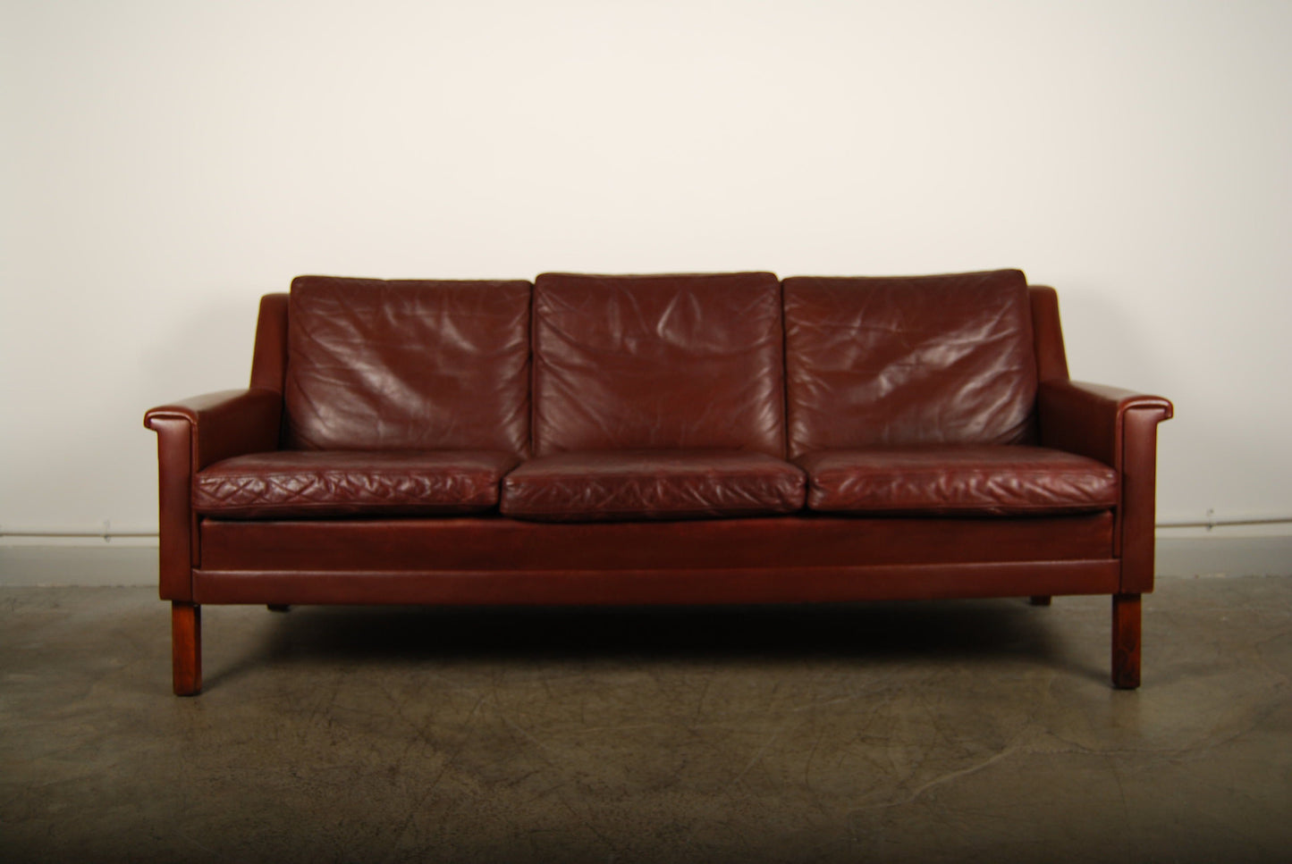 Leather three seater on rosewood legs