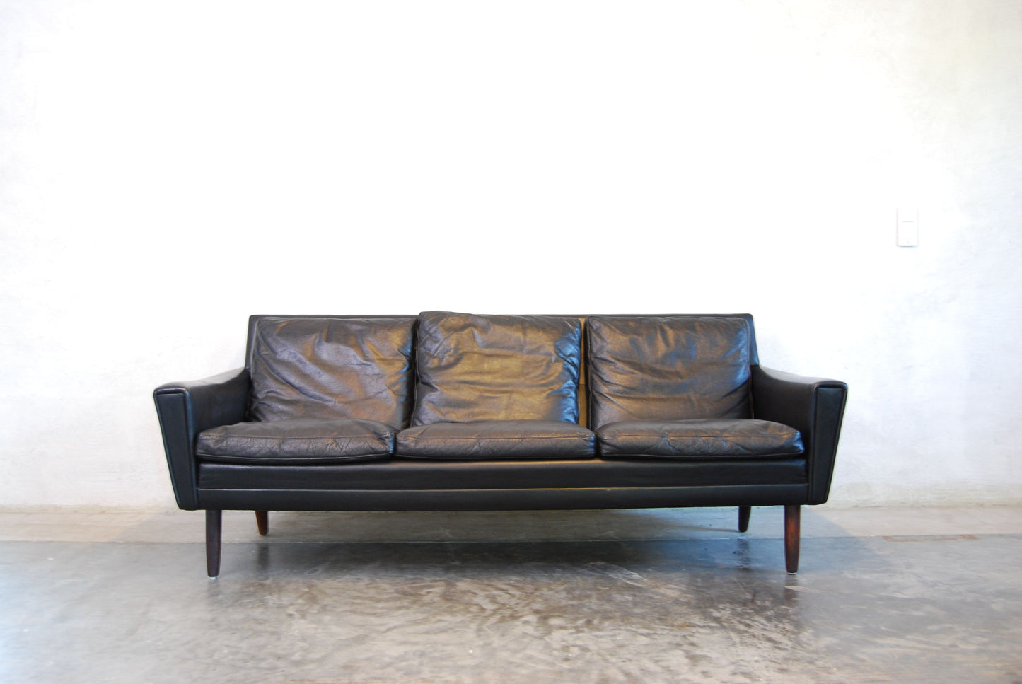 Three seat black leather sofa