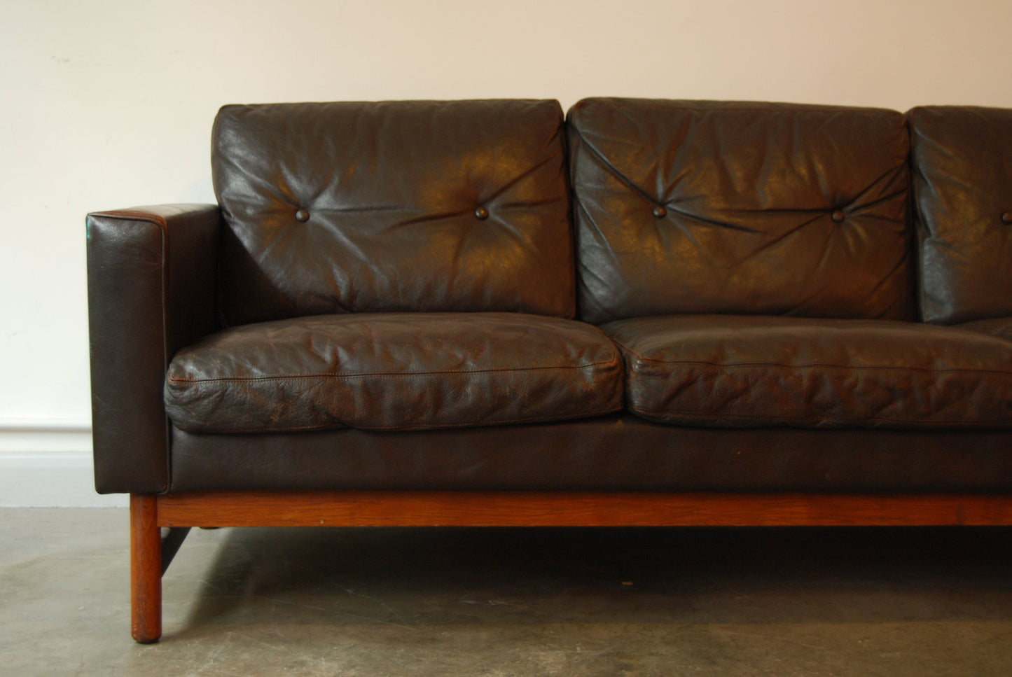 Three seat leather sofa on rosewood base