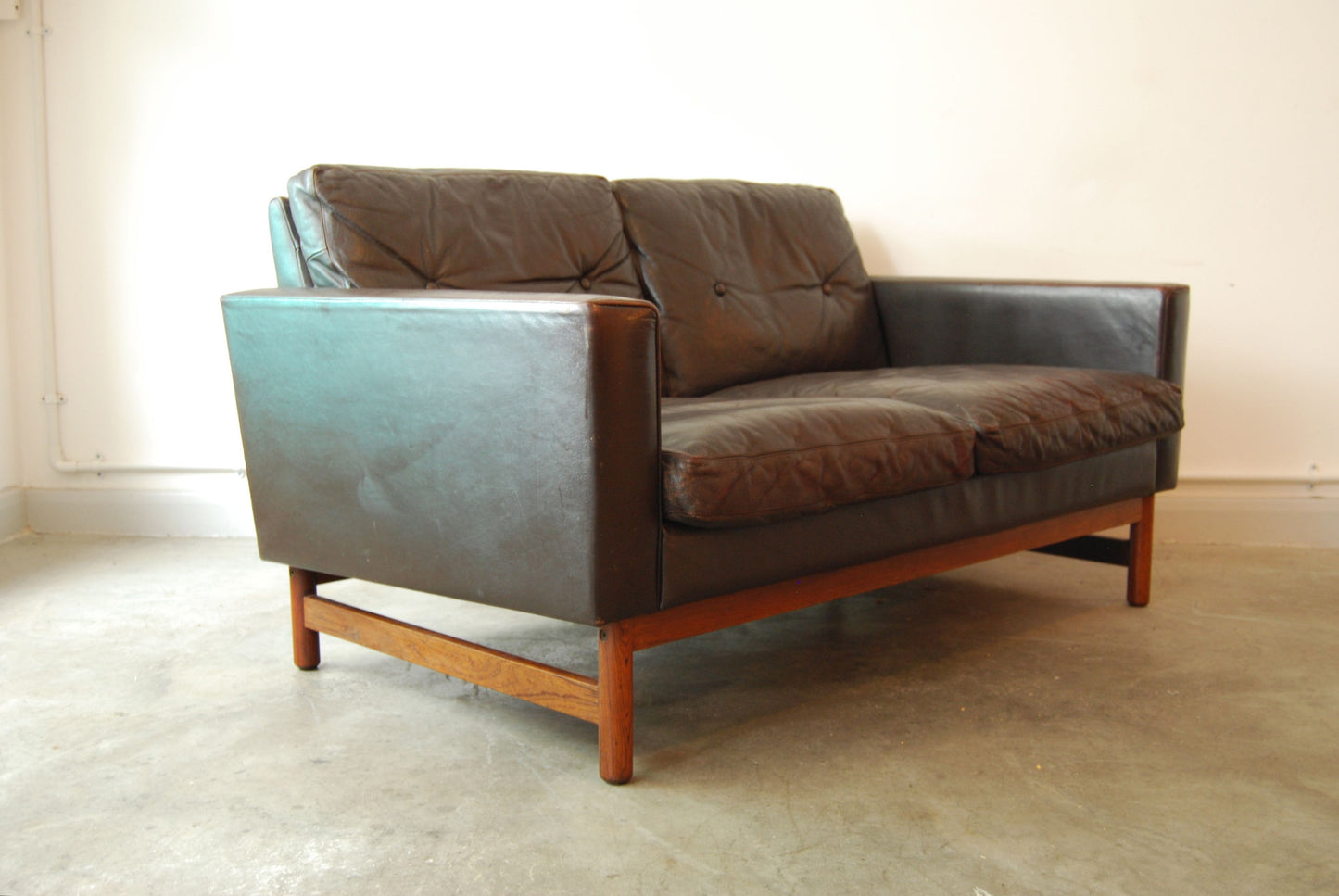 Two seat leather sofa with rosewood base