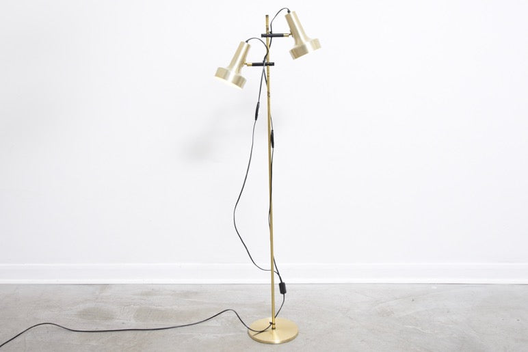 Twin-headed floor lamp with brass finish