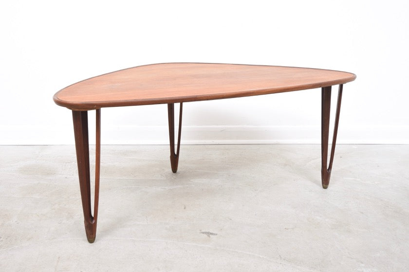 Triangular coffee table with intricate tripod legs