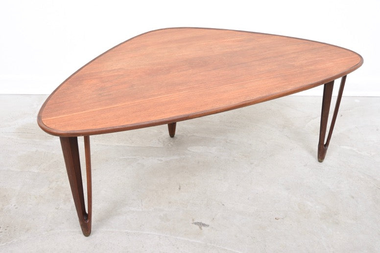 Triangular coffee table with intricate tripod legs