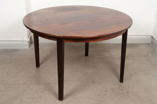 Round extending rosewood dining table