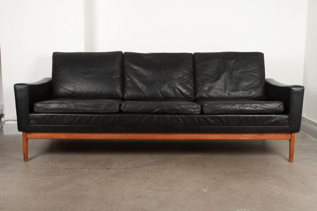 Three seat leather sofa on oak legs