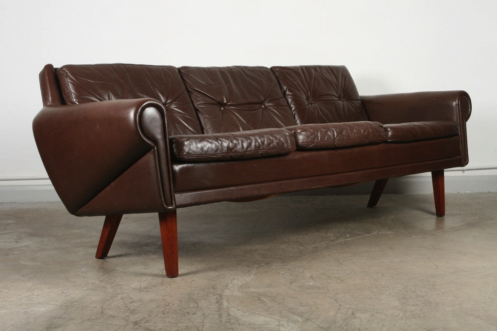 Three seat leather sofa on teak legs