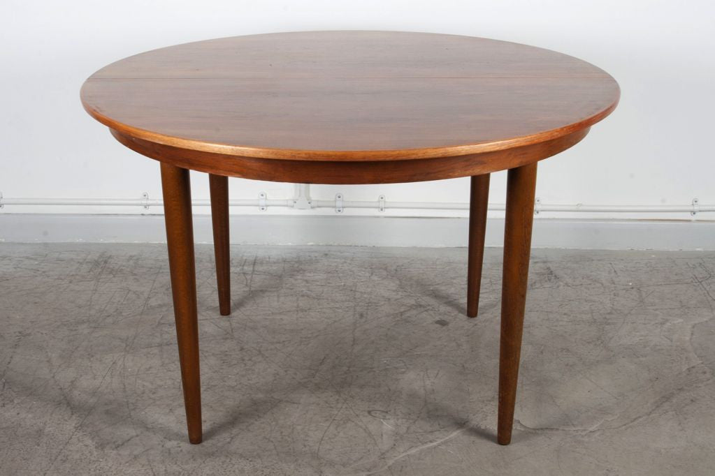Round extending rosewood dining table