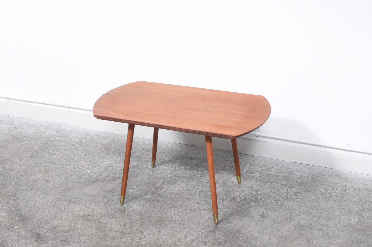 Teak table with brass-tipped legs
