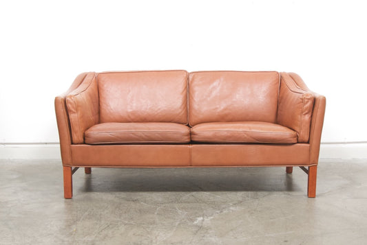 Scalloped back leather two seat sofa