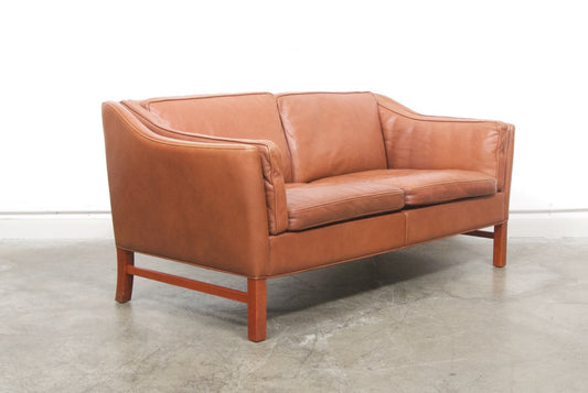 Scalloped back leather two seat sofa