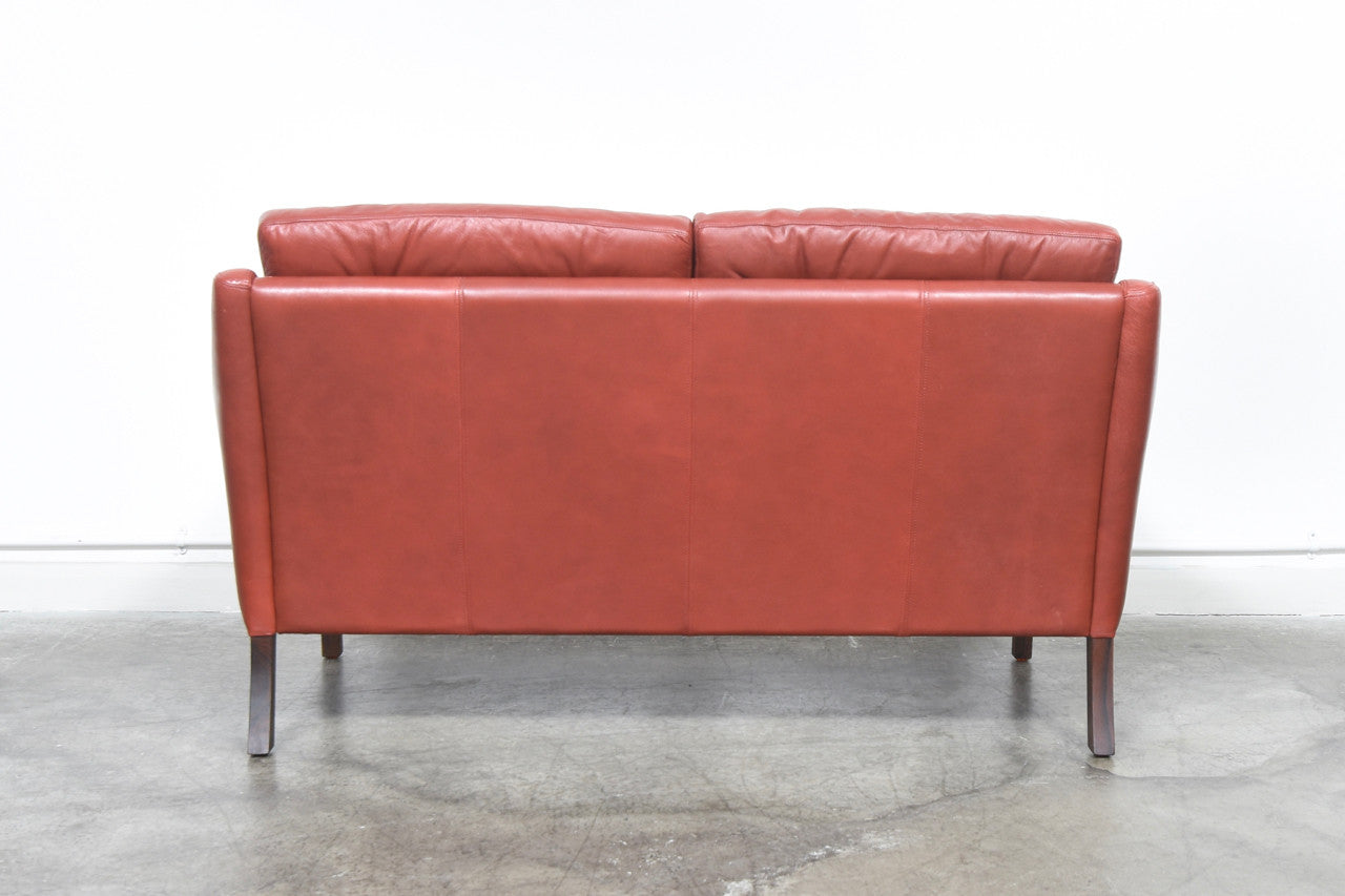 Red leather two seat sofa