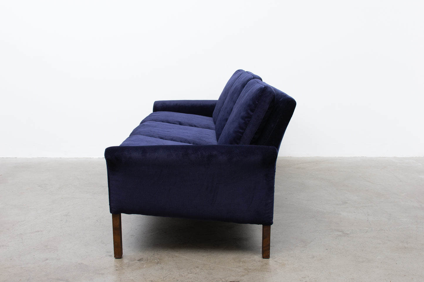 Newly upholstered: 1960s three seater in navy corduroy