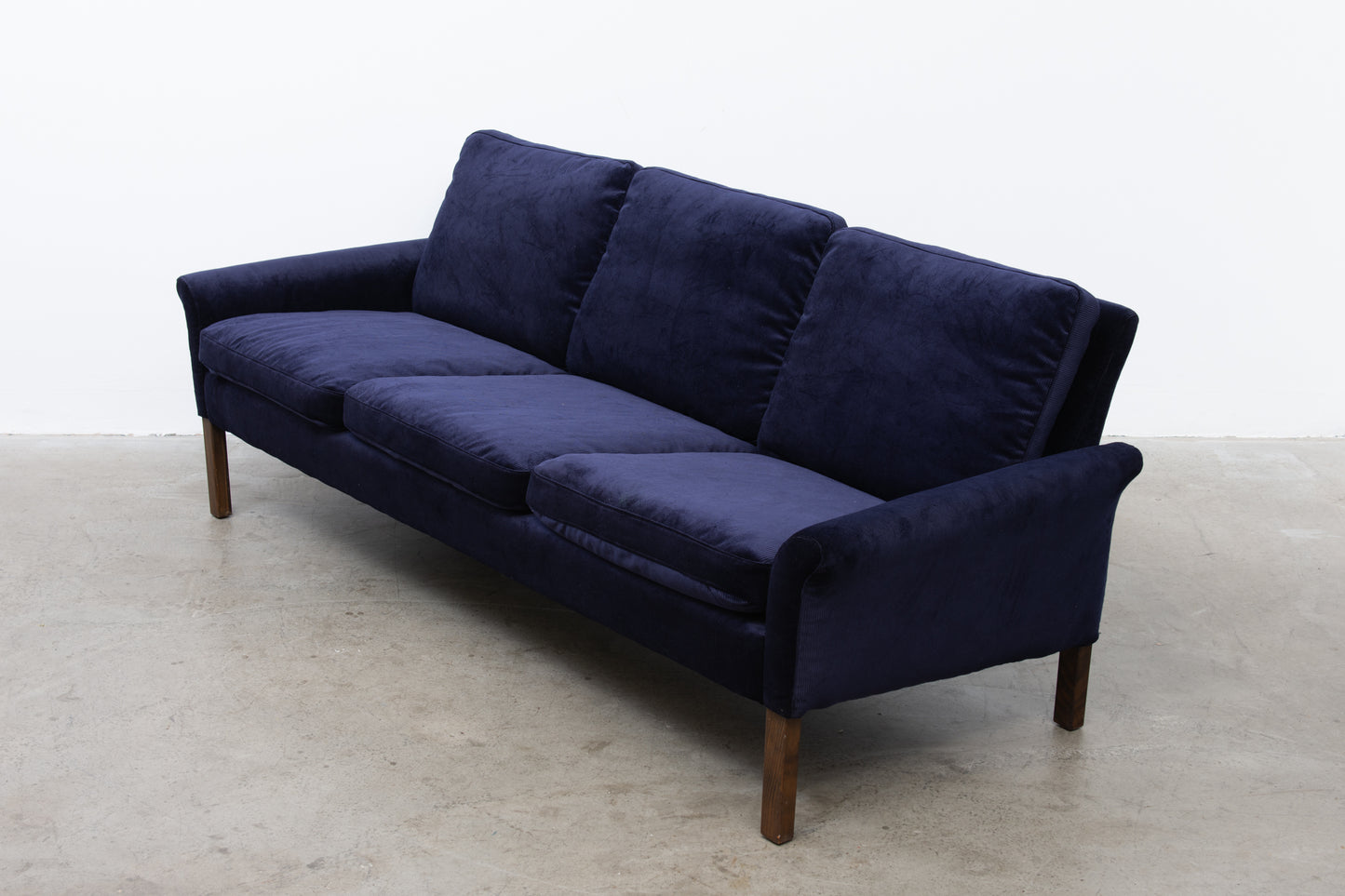 Newly upholstered: 1960s three seater in navy corduroy