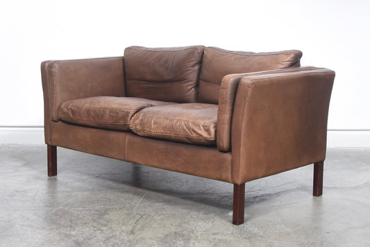 Two seat leather sofa with feather cushions