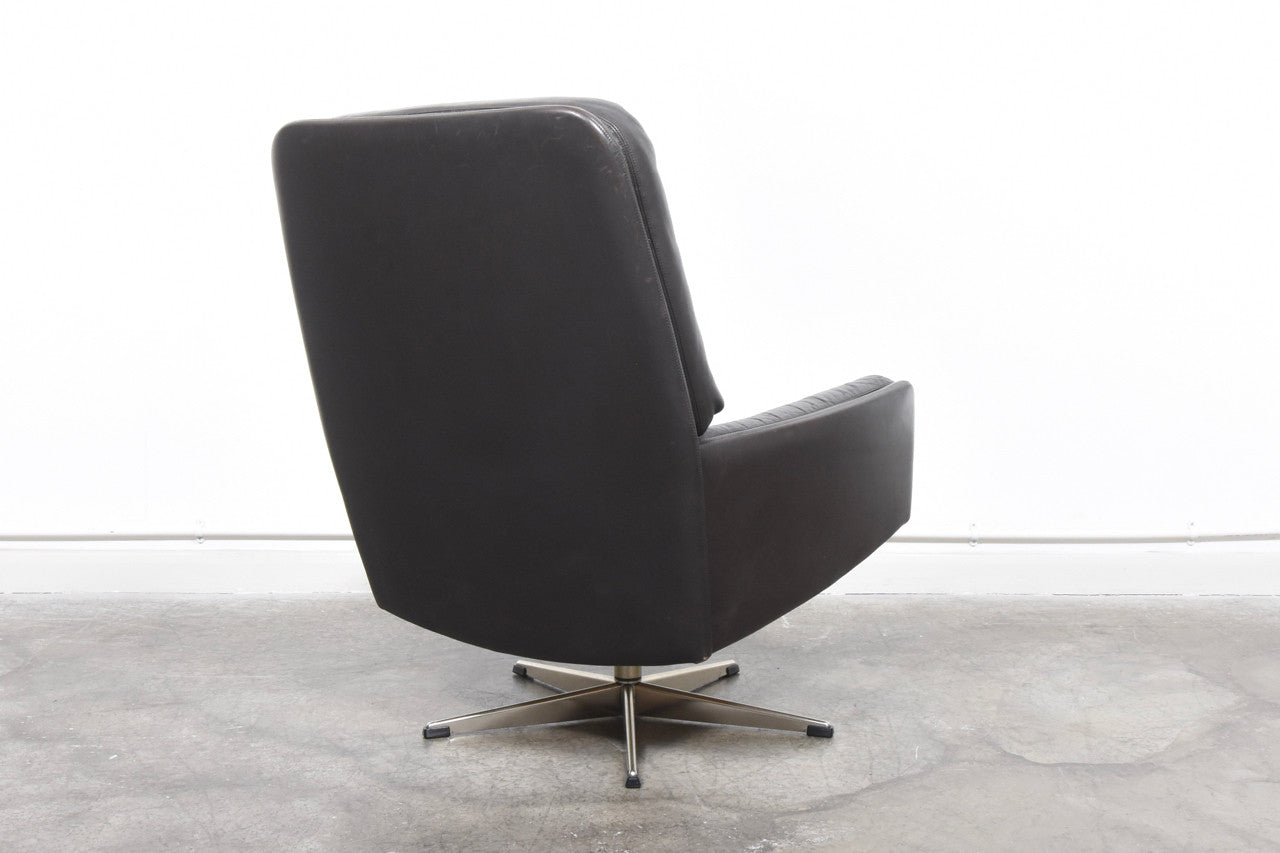 Dark brown leather lounge chair on swivel base