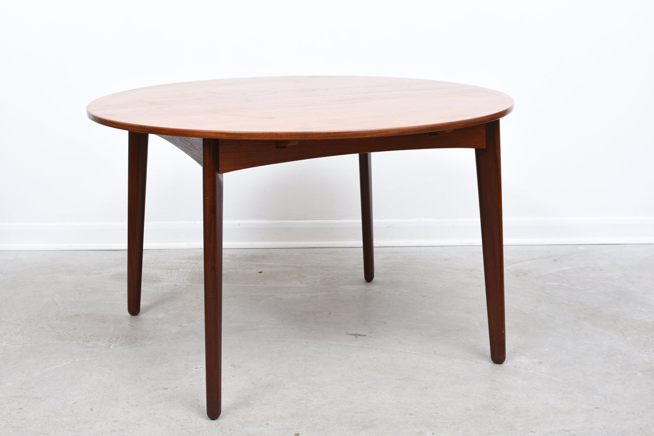 Extending dining table in teak on splayed legs